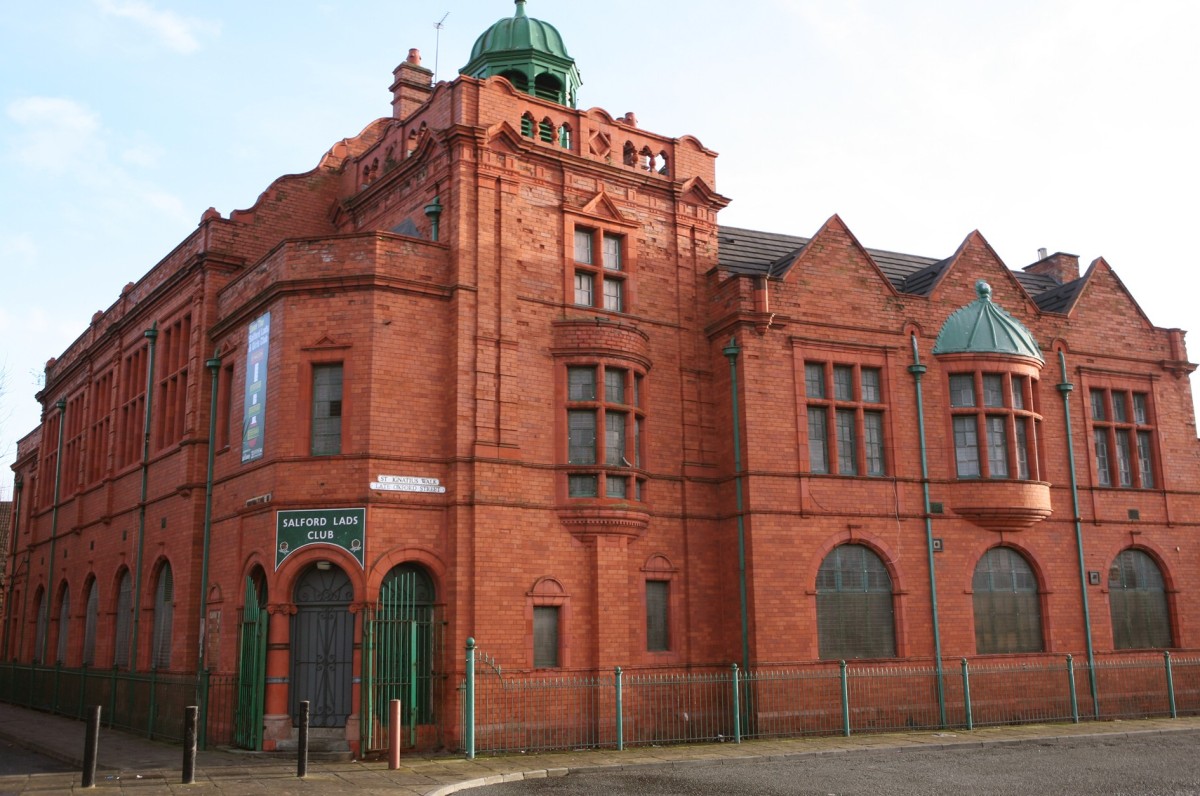 A red brick building with green trim, in victorian architecture. 