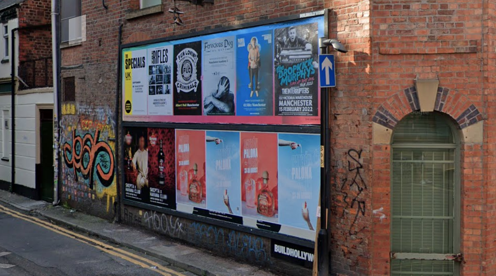 A billboard site on a red brick building with a street sign reading Carpenters Lane